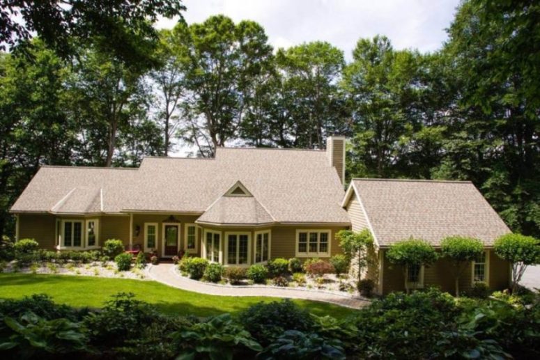 Large exterior home remodeling with green shrubs surrounding the house