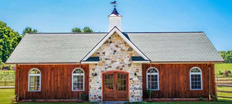 front view of red barn structure with new gray roof