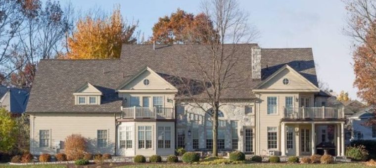 large tan home with new brown roof viewed from street