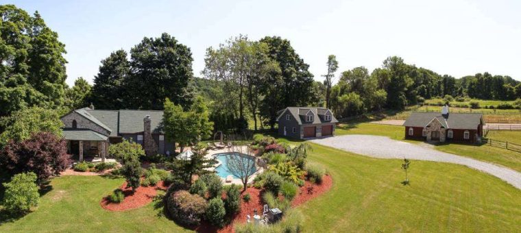 property with multiple structures with pool and lawn in between