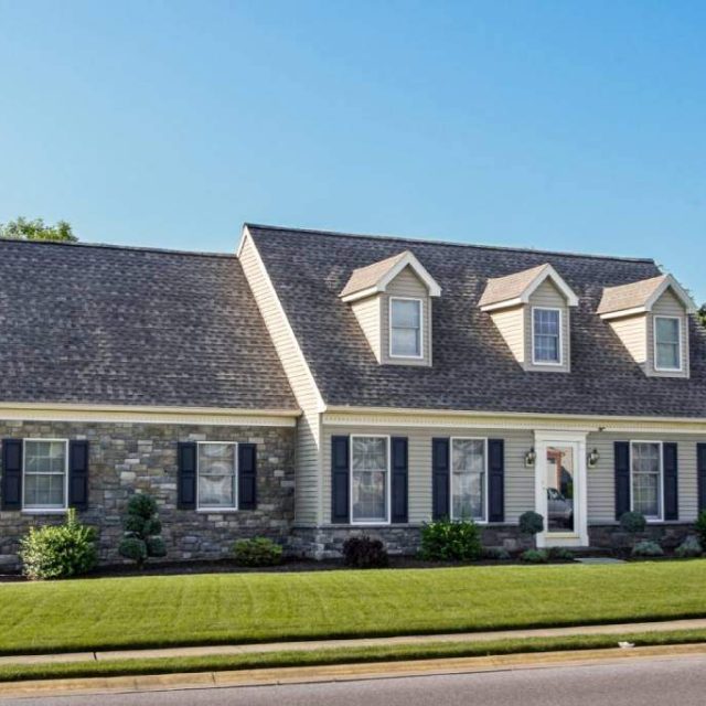 roof repair contractors installed gray shingle roof and stone facade