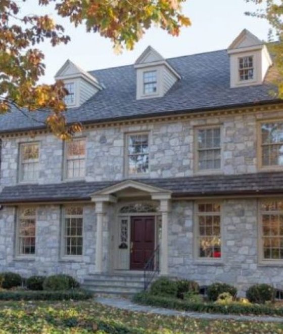 home in autumn with stone walls and multiple windows