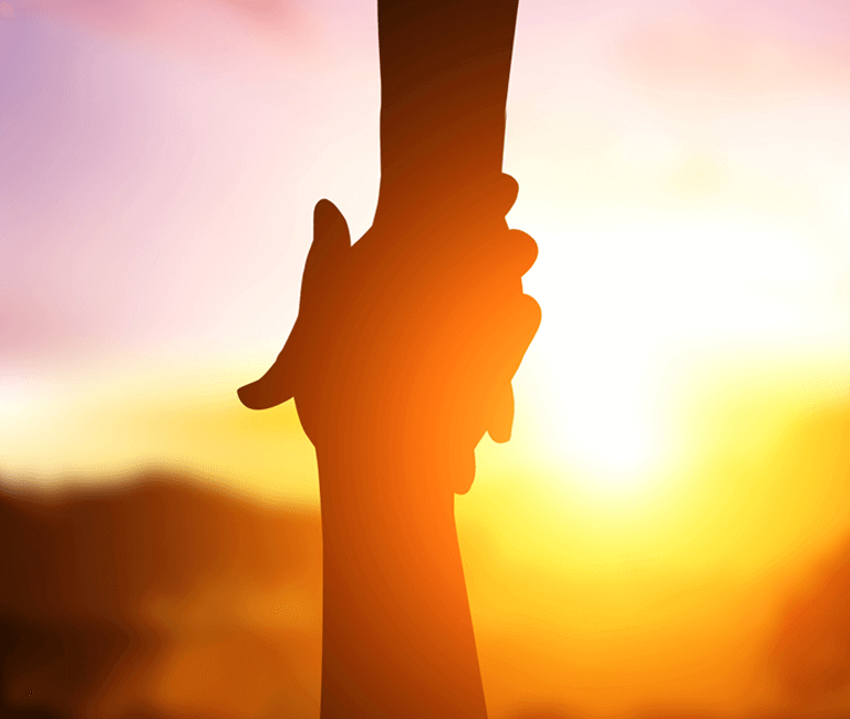 Hands holding at sunset