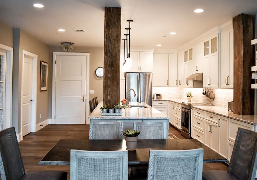 farmhouse-style kitchen renovation project with exposed wood beams and sleek white cabinetry