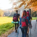 Friends with backpacks walking outdoor together, trekking and tourism