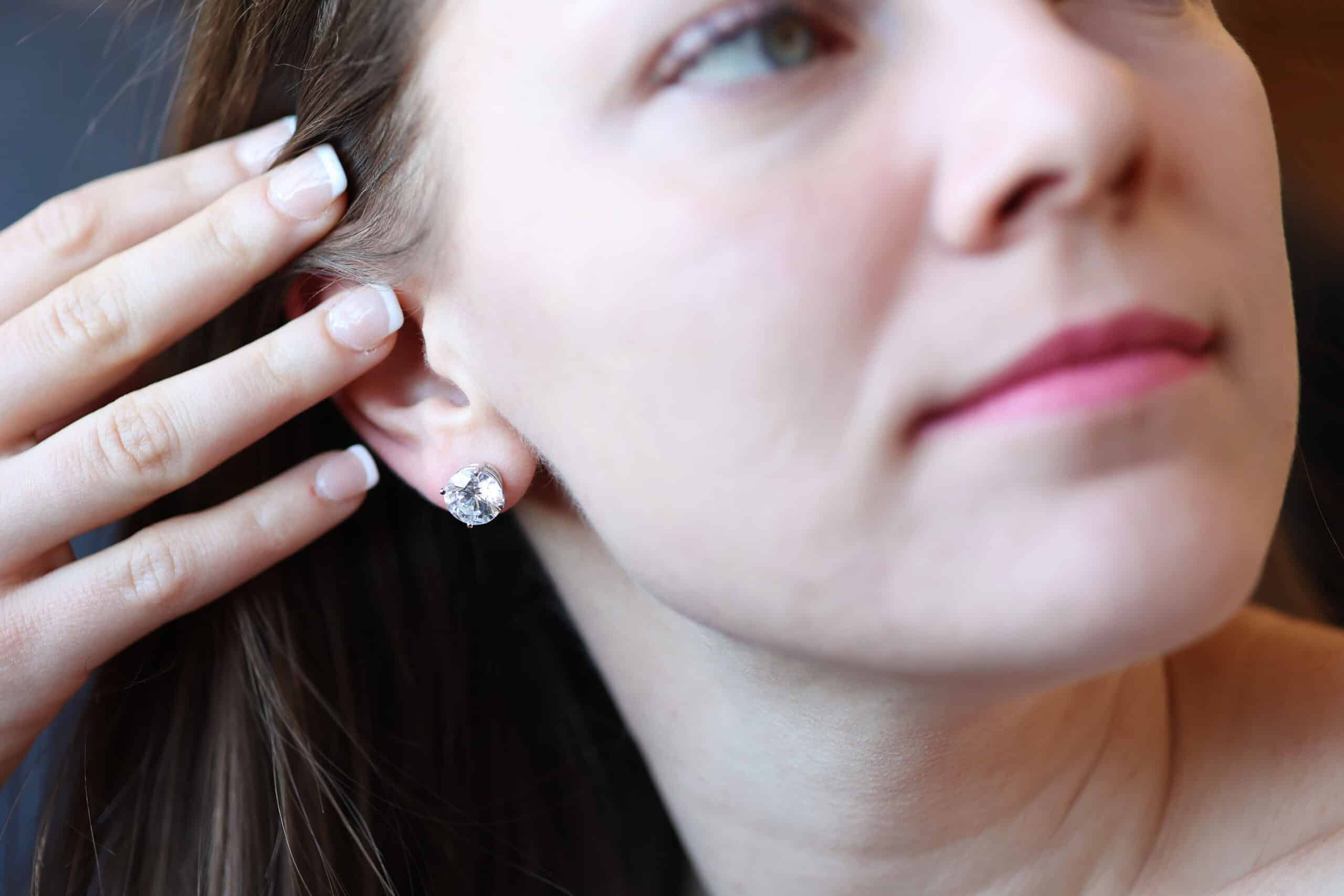 Diamond stud earrings on a person
