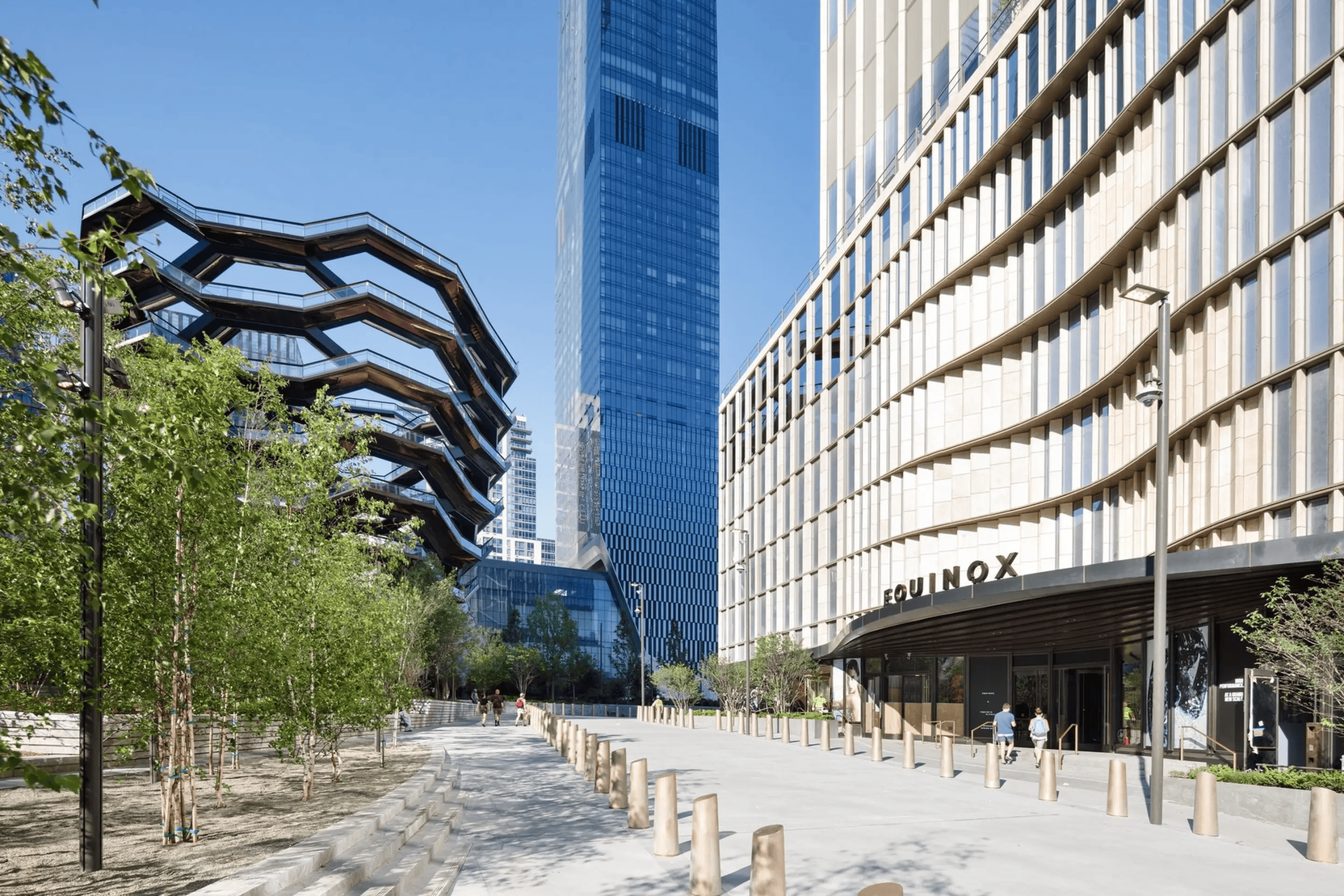 The exterior of Equinox Hotel on a sunny day with Vessel in the background