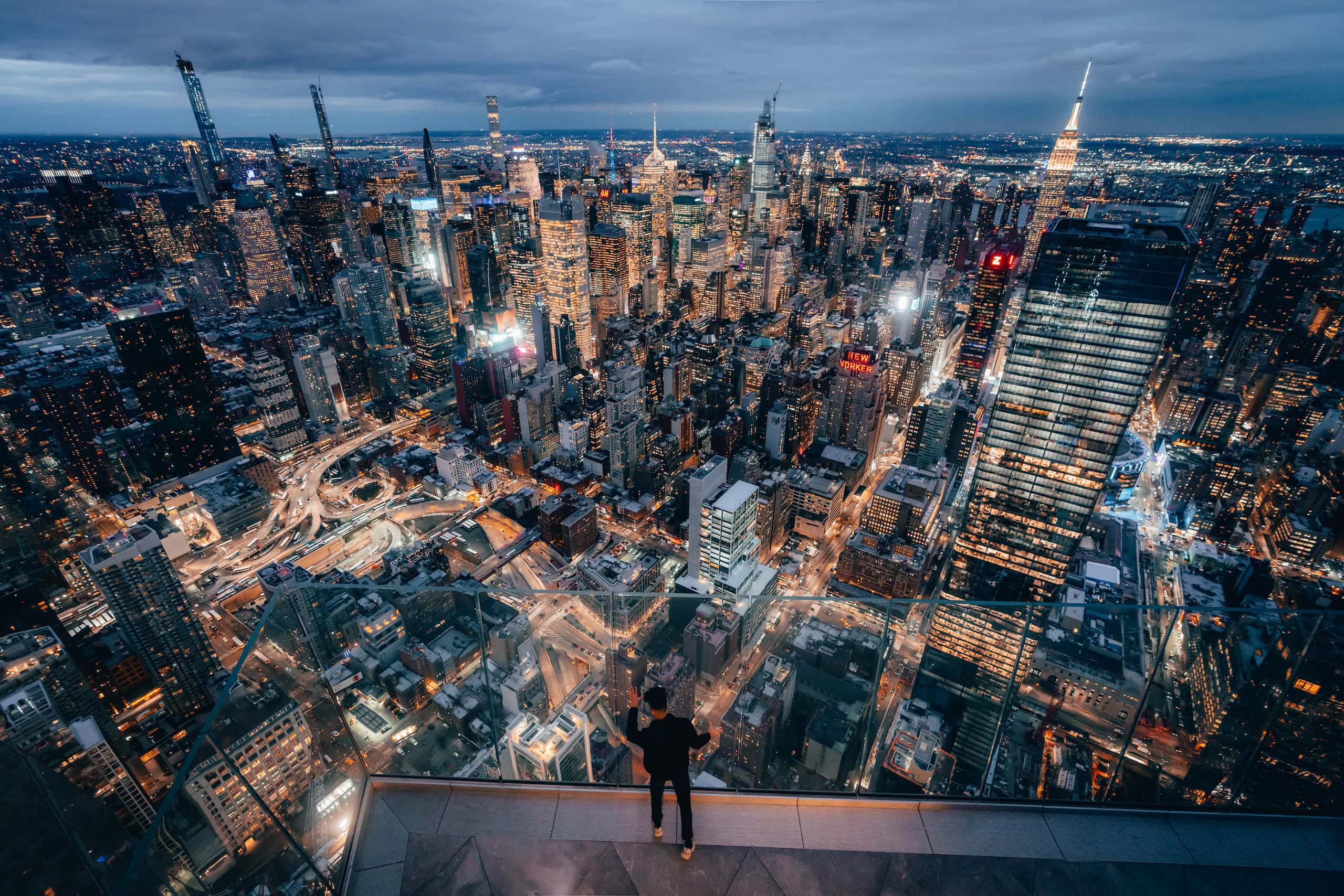 A man looks out over New York City from The Edge at dusk