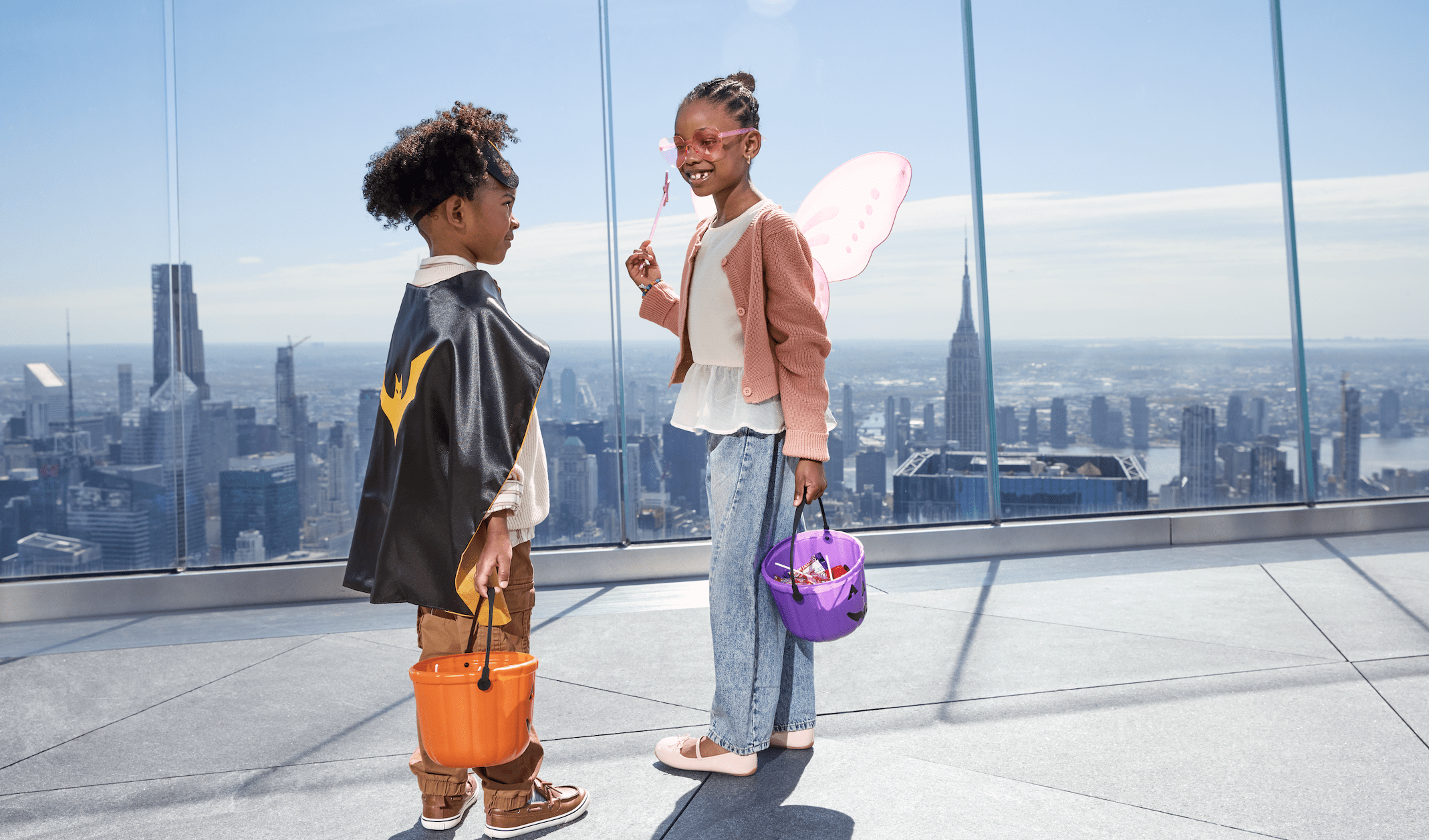 two children dressed up for halloween in batman and butterfly costumes.
