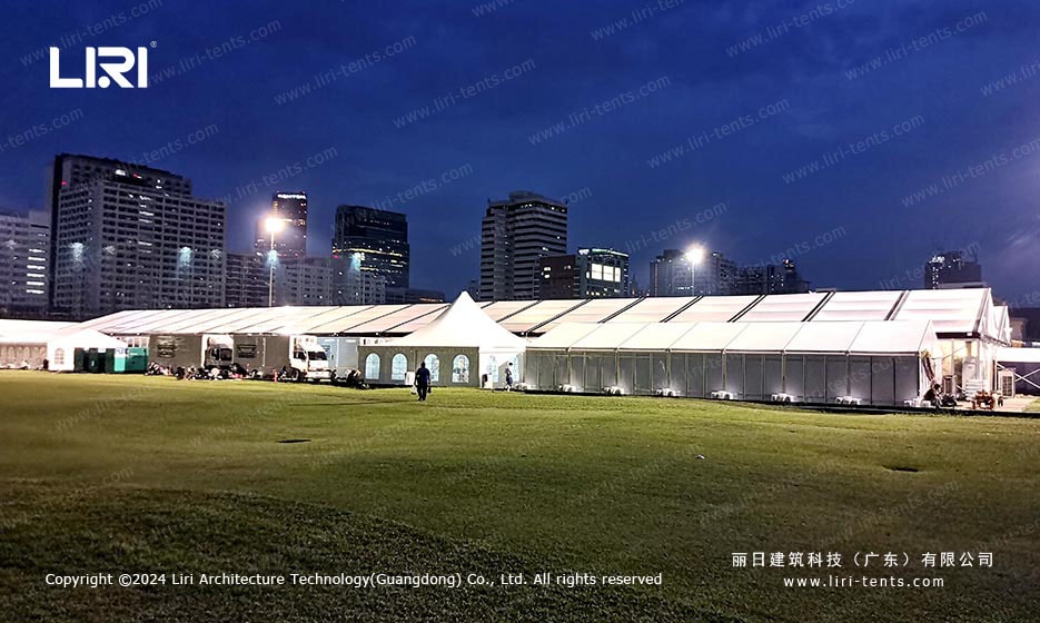 Exterior night view of illuminated clear span event tent