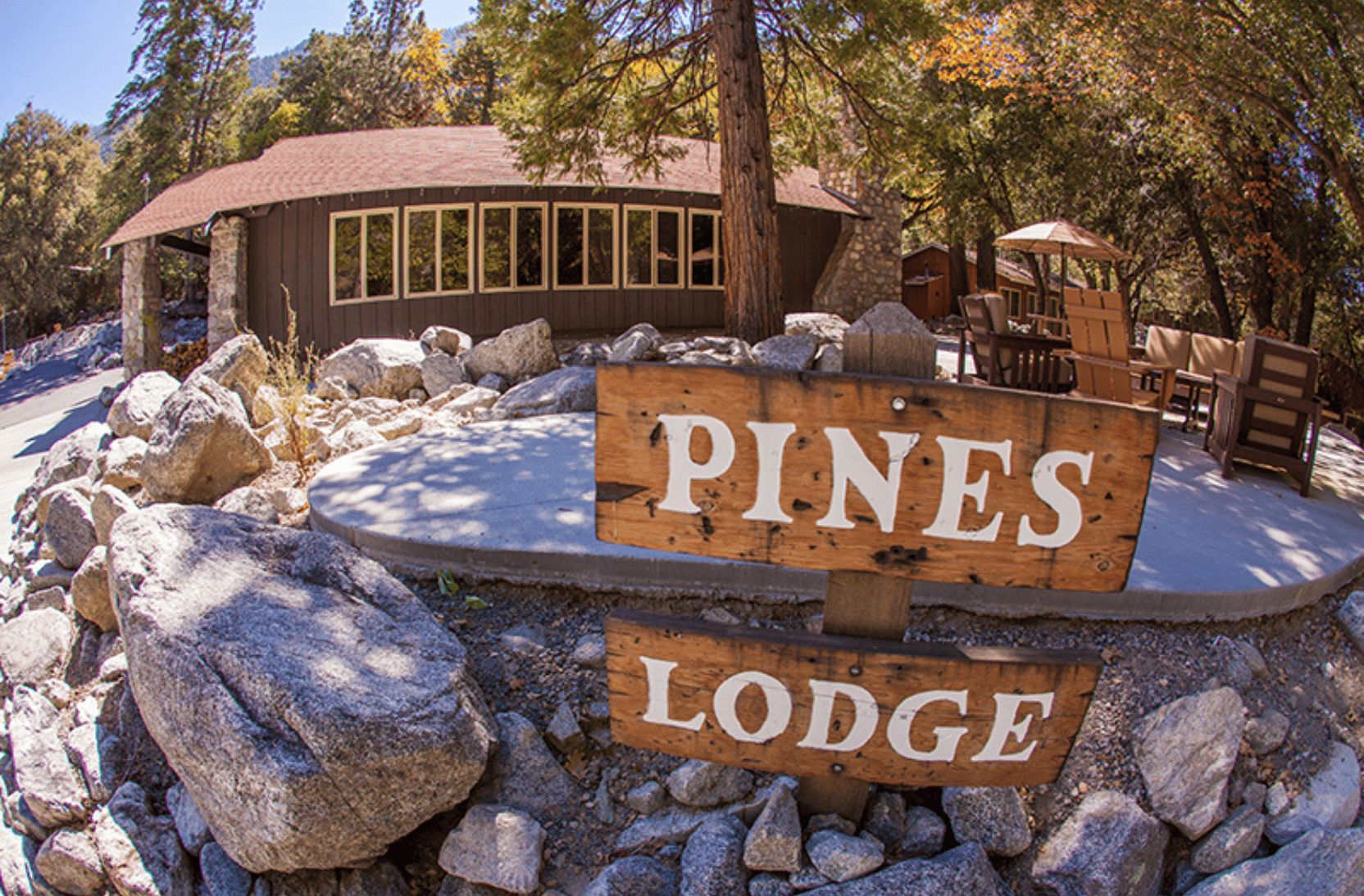 Outside of building with sign that reads "Pines Lodge"