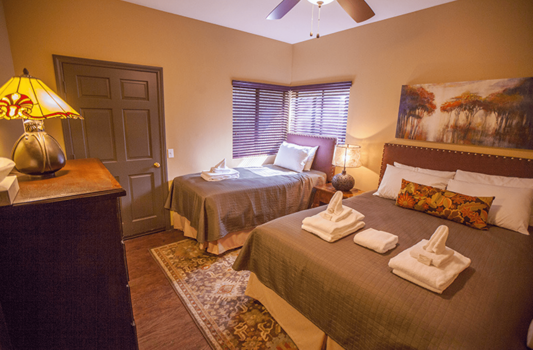 A bedroom with two double beds with towels on the bed
