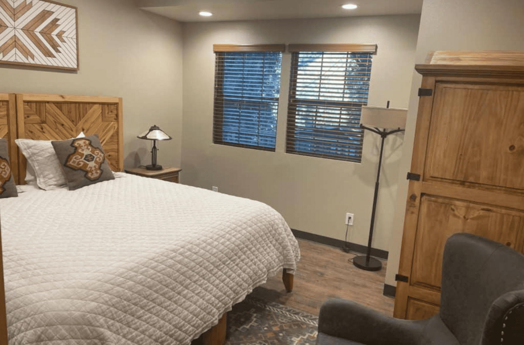 King bed in bedroom with lamp and side table and wardrobe