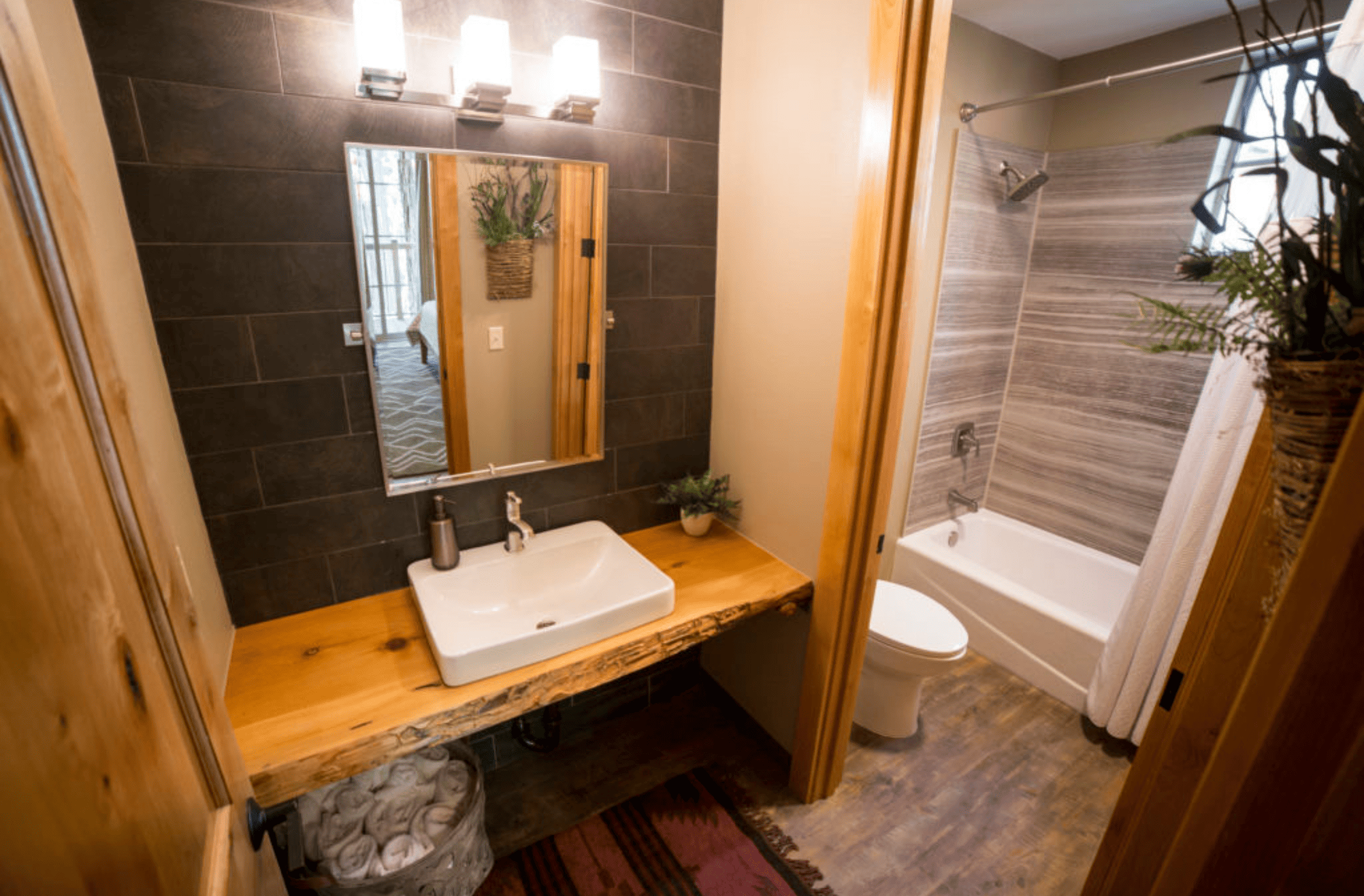 bathroom with raised sink and vanity with a door leading to the shower and tub