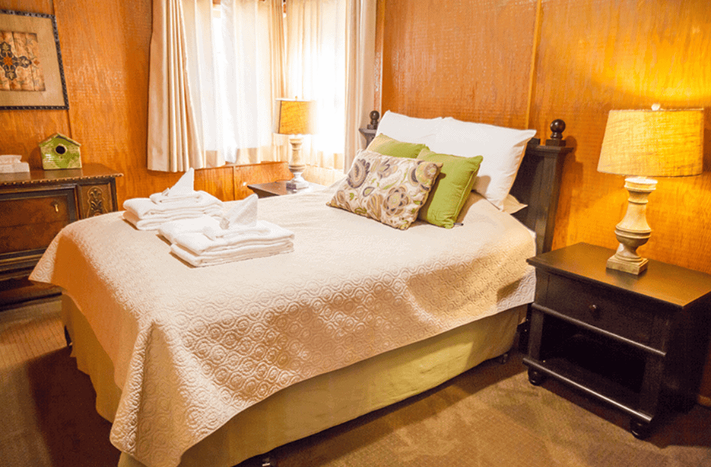 Room with a double bed in it with two night stands with lamps on them