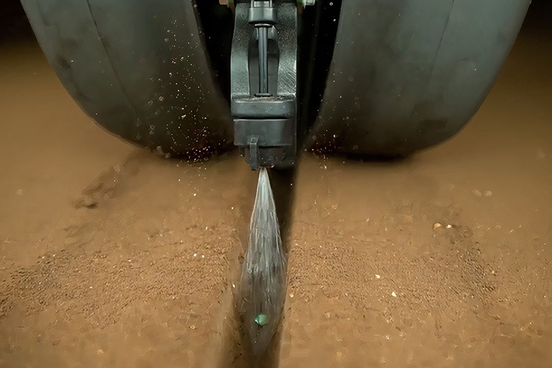 As each individual seed is in the process of going into the soil, a robot will spray only the amount of fertiliser needed, about 0.2 millilitre, directly onto the seed at the exact moment as it goes into the ground. - Photo: John Deere