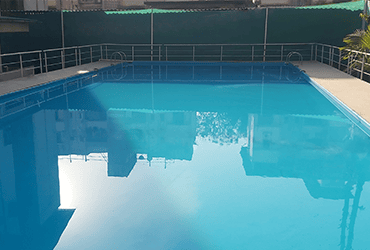 Resort-style swimming pool with lush surroundings