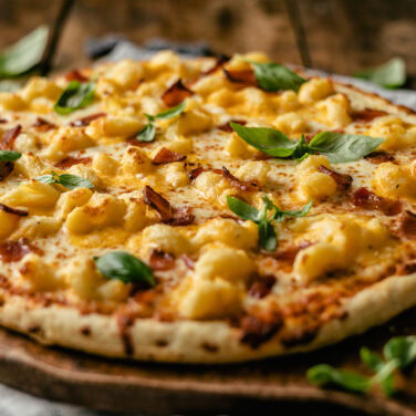 Pizza topped with bacon and mac n cheese