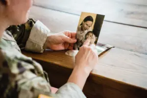 Divorce Statistics - Service member looking at a photo of their family.