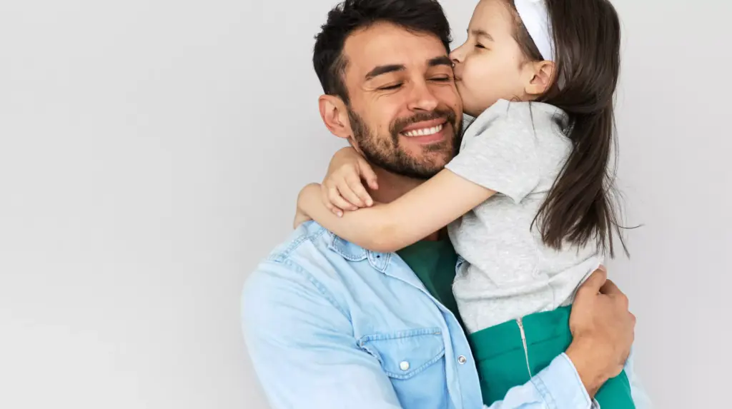 Daughter kissing her father's cheek.