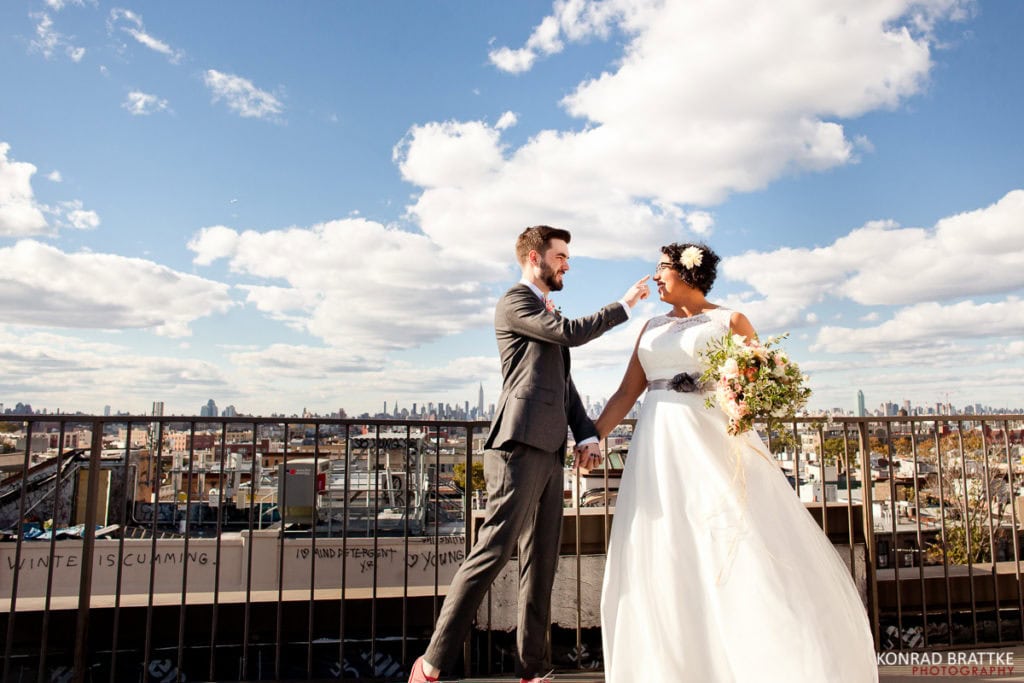 A Brooklyn wedding with the bride and groom standing on a rooftop overlooking the city.