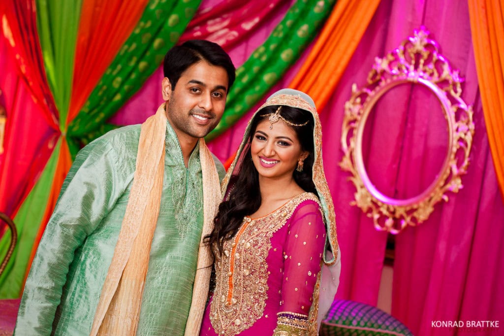 A mesmerizing Indian couple, adorned with stunning mehndi designs, striking a pose for an exquisite photo captured at Antuns.