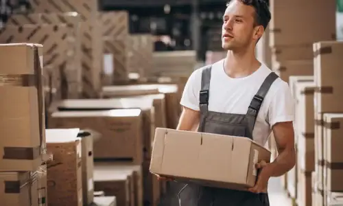 Young man working at a warehouse with boxes