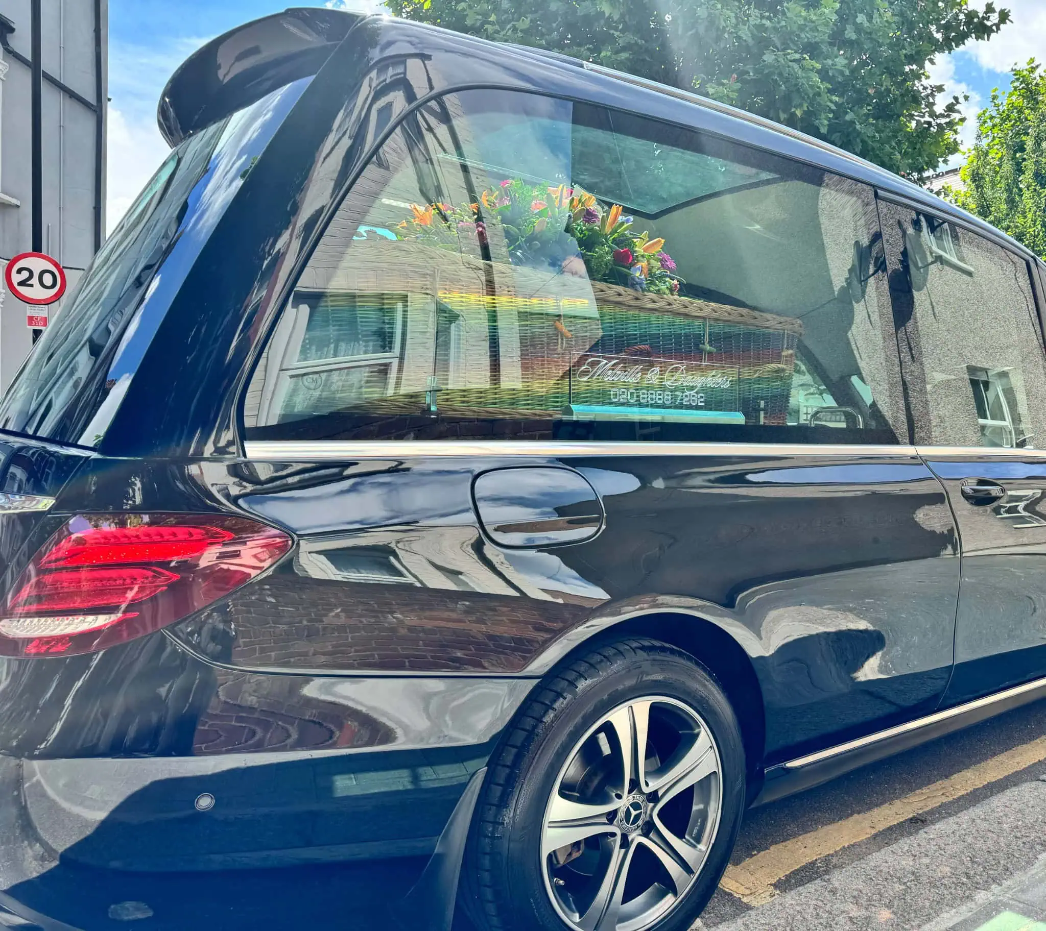 Melville & Daughters hearse carrying a rainbow coffin