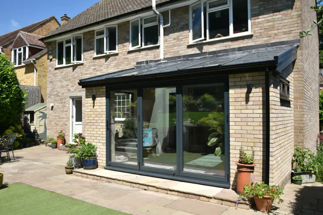 Single storey extension with black frames and a glazed roof panel