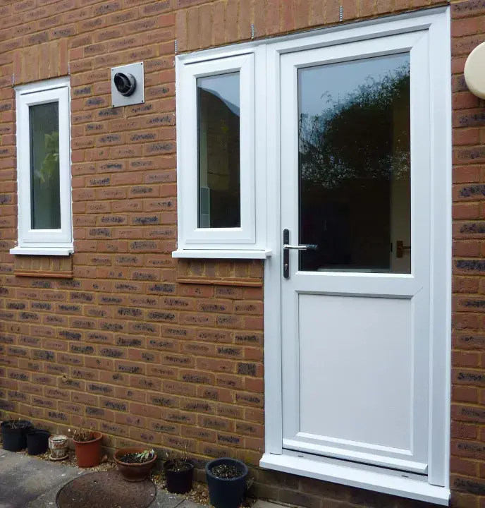 White uPVC back door with a large glazed panel fitted to a brick home