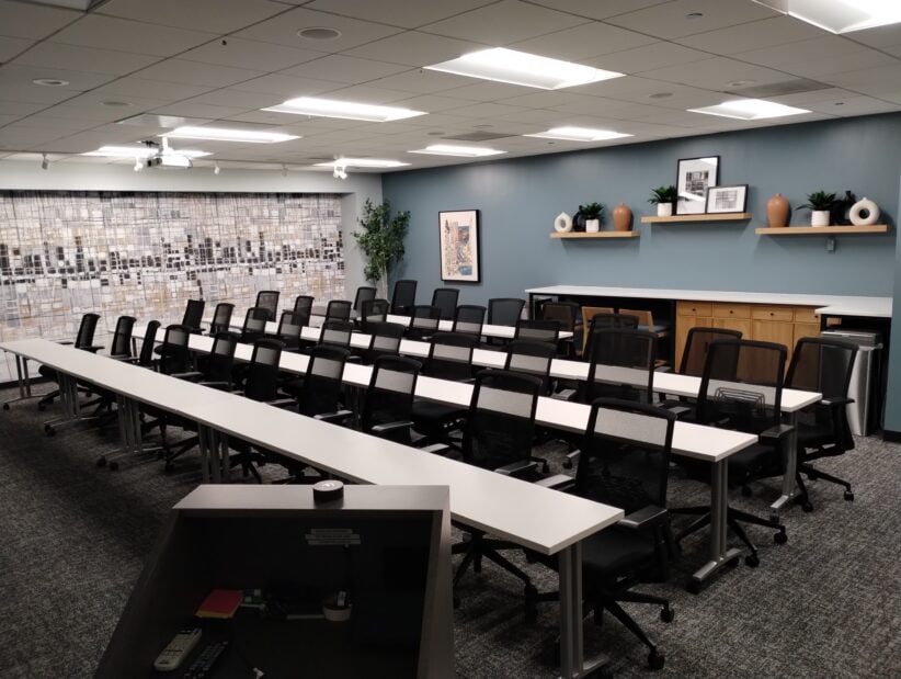 Modern office meeting room with ergonomic chairs and workspace desks.
