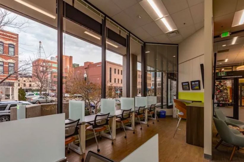 Modern coworking space at Office Evolution with private workstations and large windows.