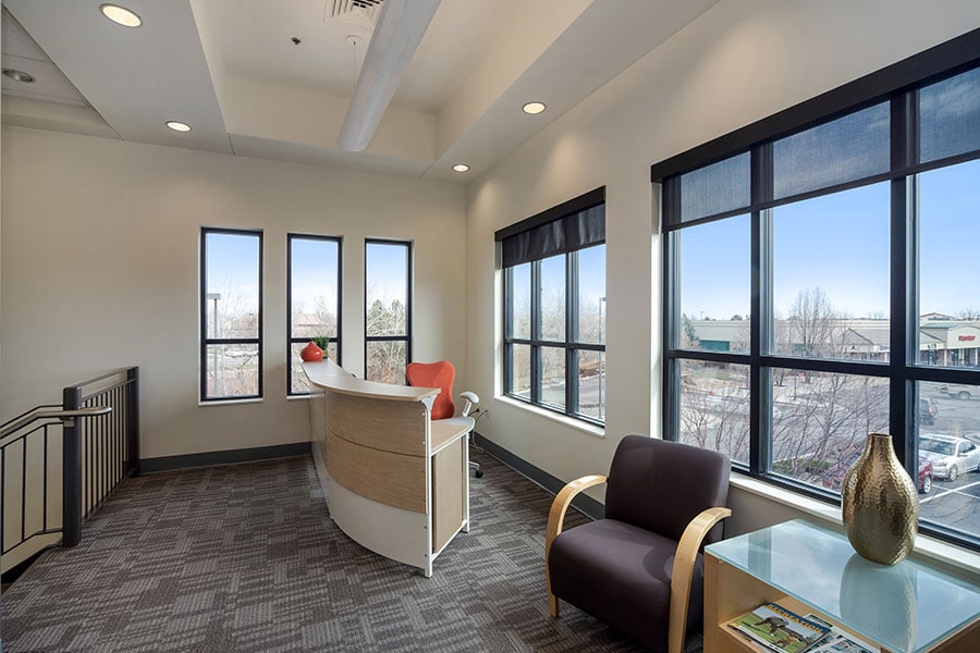 Modern office reception area with large windows and comfortable seating options.