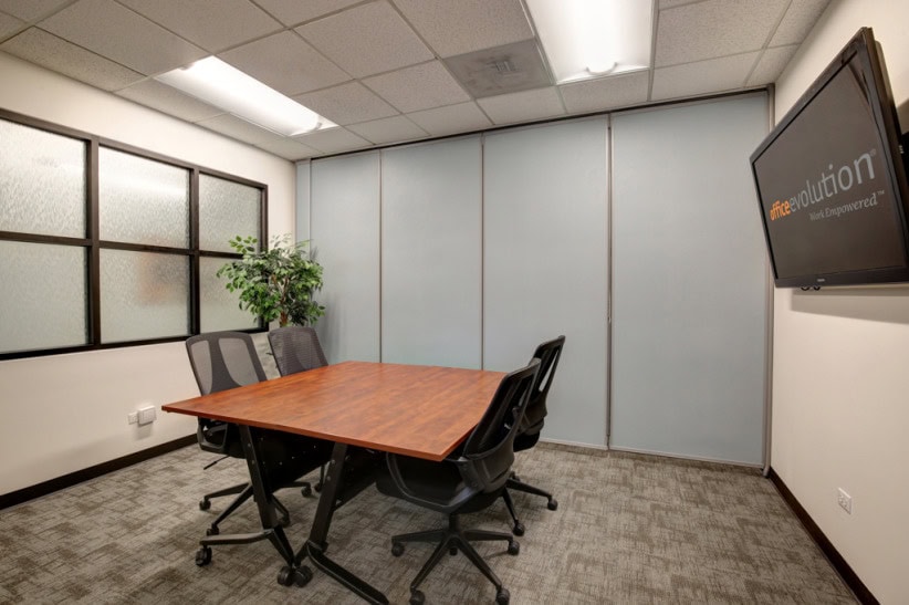 Modern office conference room with meeting table and chairs for business collaboration.