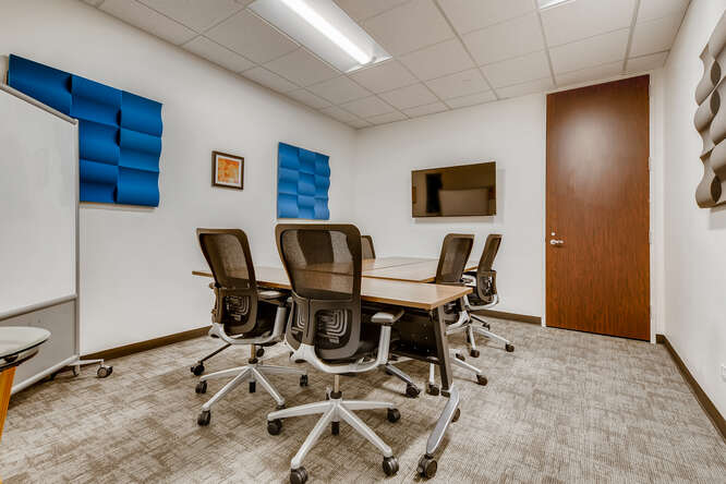 Modern office meeting room with ergonomic chairs and soundproof wall panels for productive collaborative work.