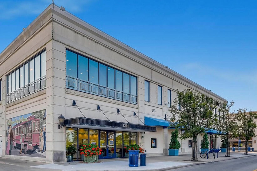 Office evolution coworking space in a modern building with outdoor seating and art murals.