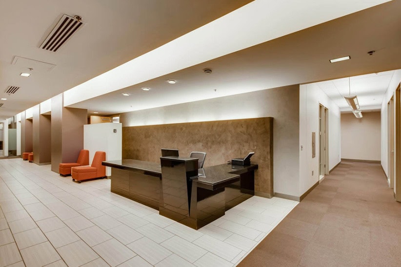 Modern office reception area with comfortable seating and sleek black desk at Office Evolution.