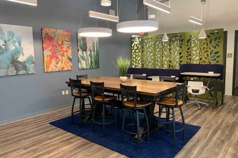 Modern coworking space with artwork, collaborative table, and private work area at Office Evolution.