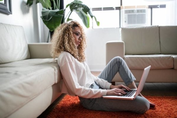 Moing Overseas For Work, woman sitting next to her couch on the computer researching