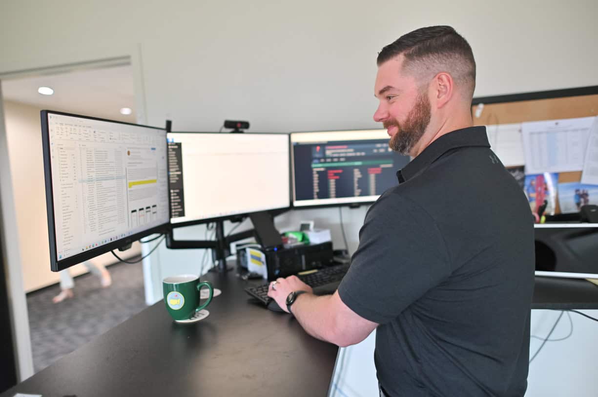 PCR Business Systems team member using AI tools at multi-monitor workstation in Northeast Ohio office