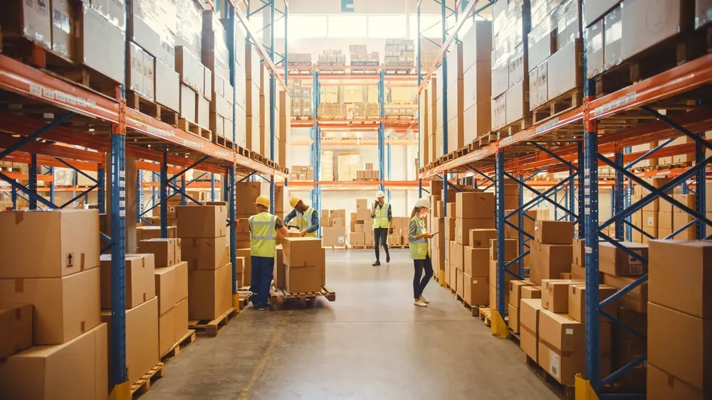 A shipping warehouse with four workers taking inventory.