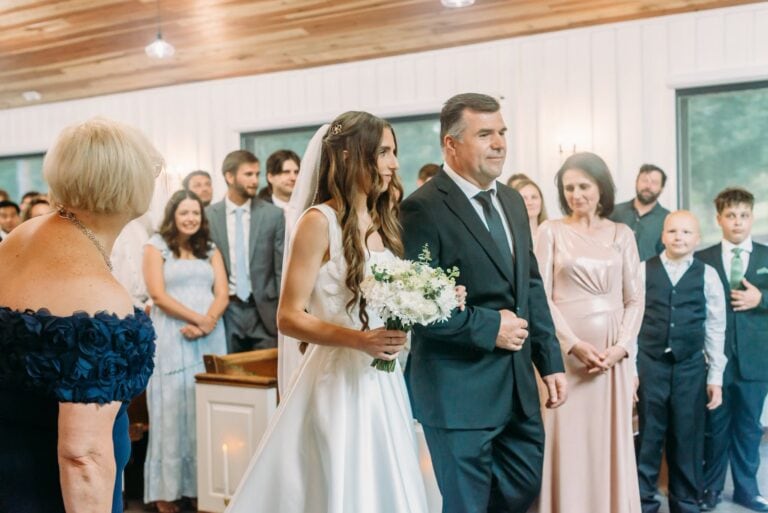 Erina walks down the chapel aisle with her father at Romaine Valley Weddings & Events in Fenton, MO