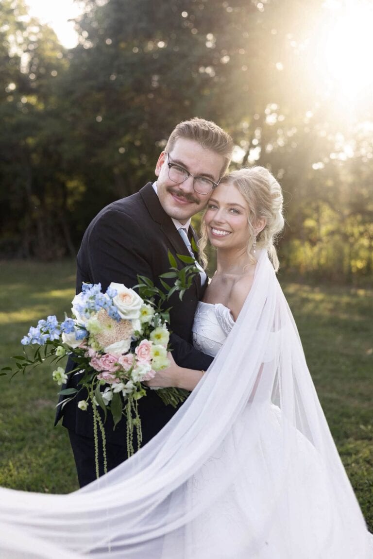 Noah and Claire smile together in golden sunlight on the grounds at Romaine Valley Weddings & Events in Fenton, MO