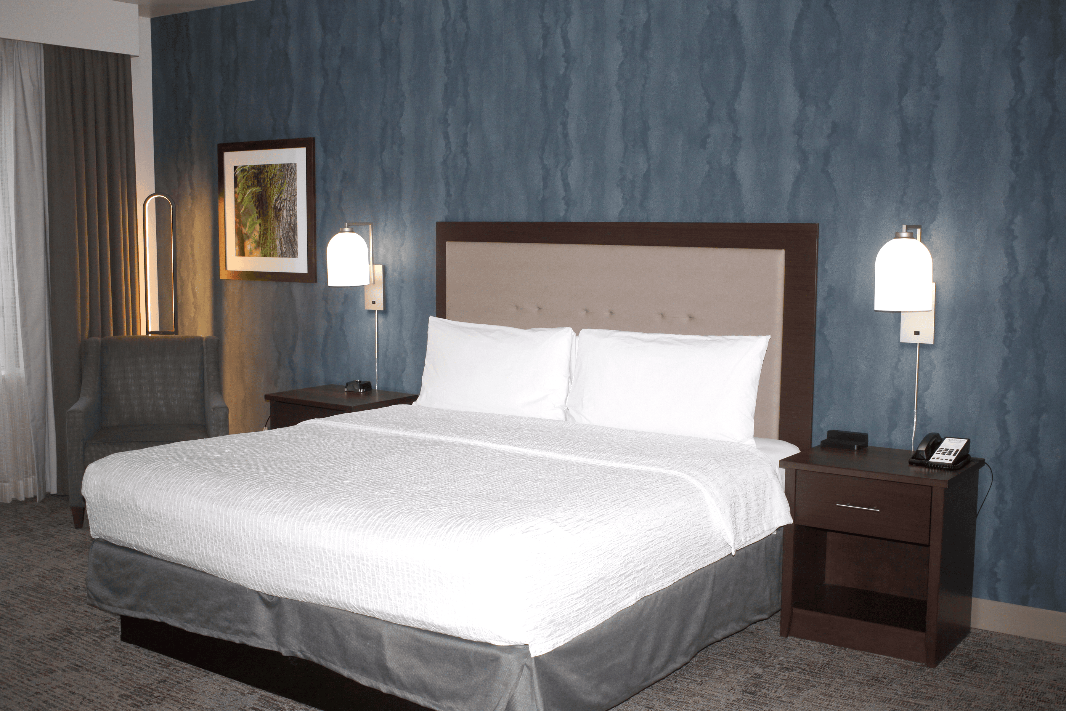 A refreshed suite at the Homewood Suites by Hilton Seattle-Issaquah, with new carpet, wallpaper, and furniture.