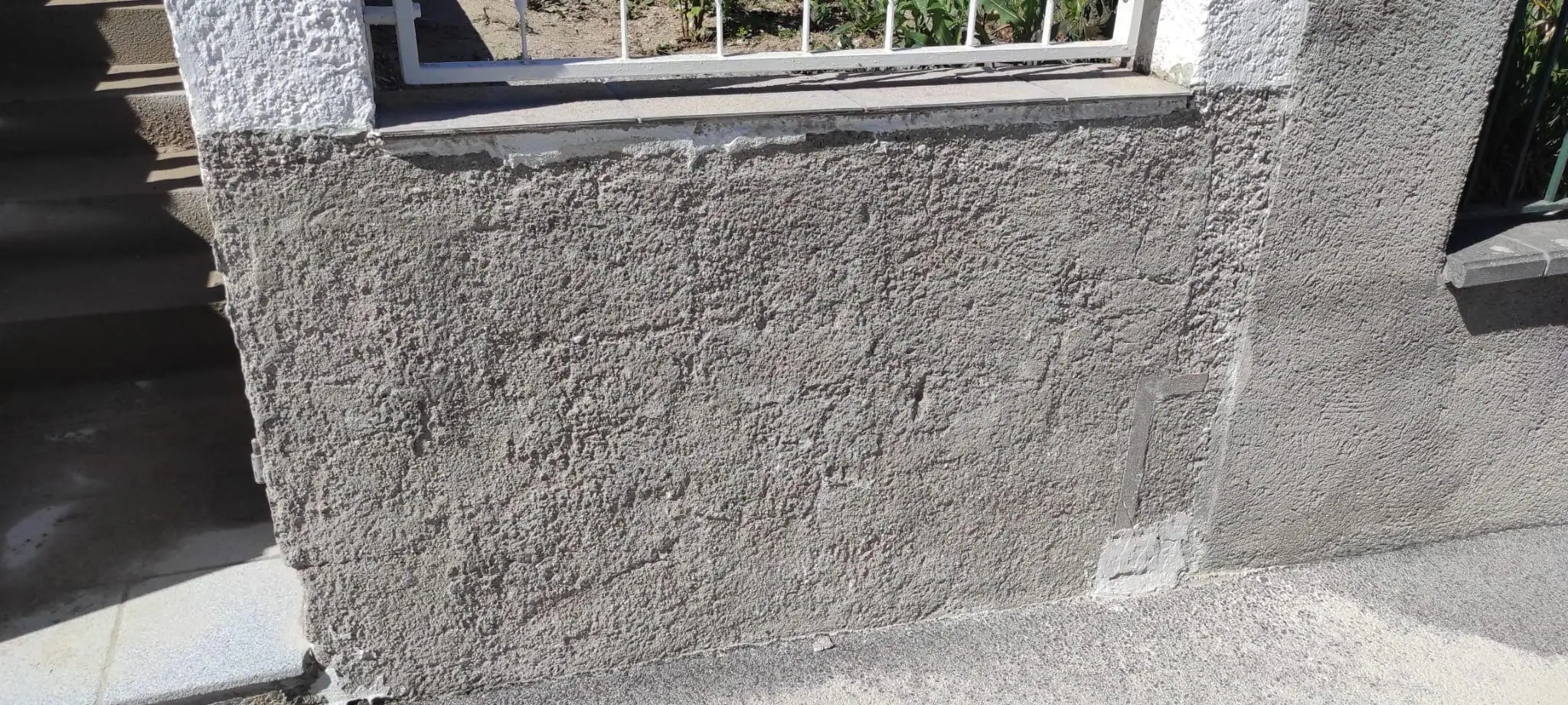 Sauberer Untergrund nach dem Entfernen von Fliesenkleber am Gebäudesockel
