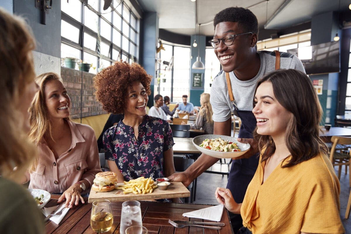 Waiter Serving Group Of Female Friends in a restaurant