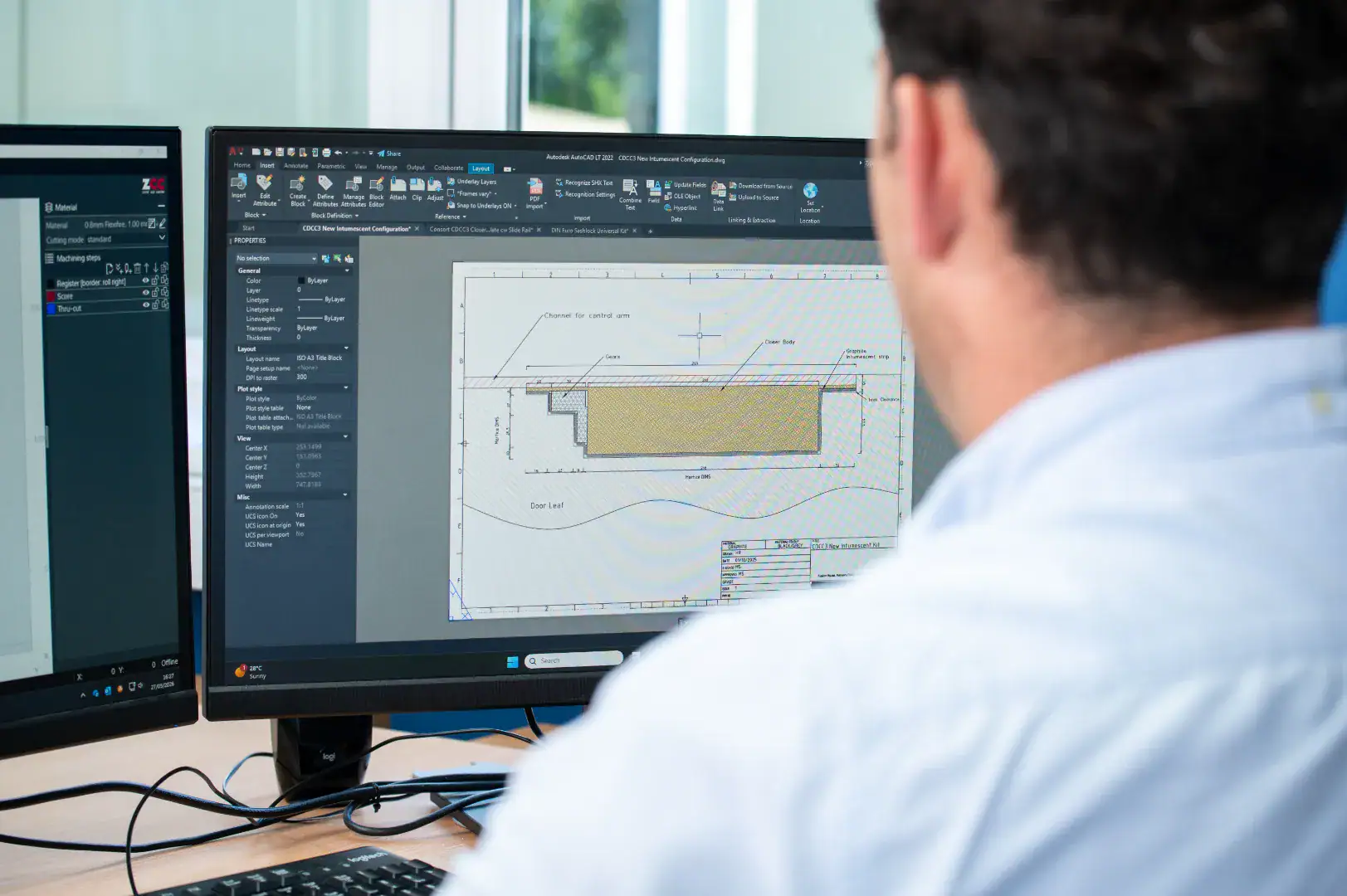 Person reviewing a technical CAD drawing on a computer screen.