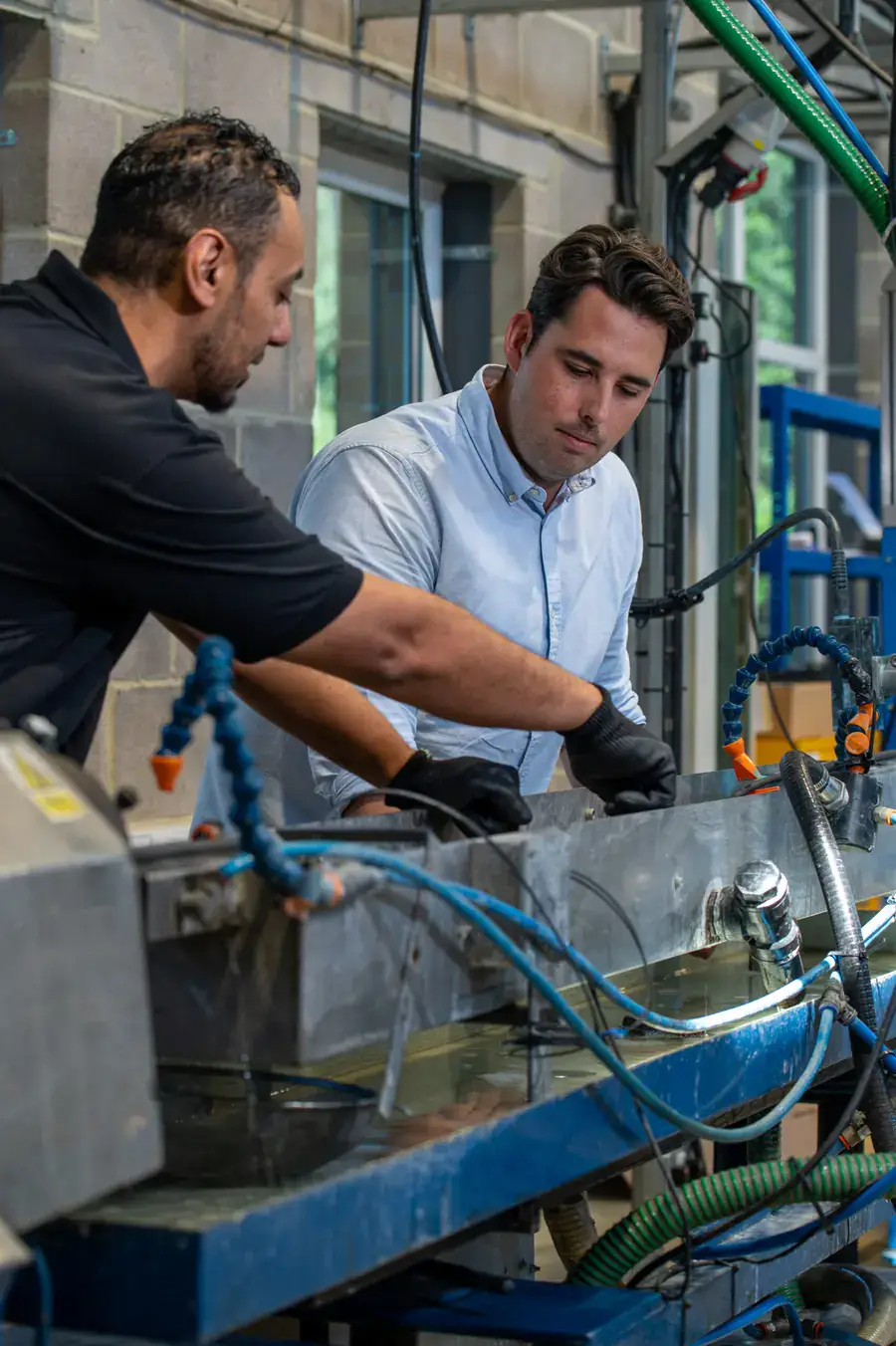Two colleagues examining equipment on the factory floor