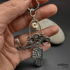 The sorcerer, large earring with a skull, moons and large angel wing