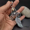 The sorcerer, large earring with a skull, moons and large angel wing, small hoop